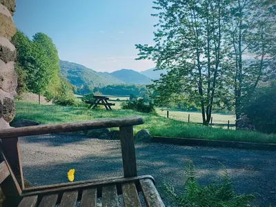 a wooden bench with a picnic table in the background at The Duddon Nest in Ulpha
