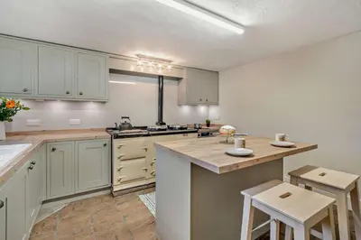 a large kitchen with white cabinets and a counter top at 4 Bed in Kinniside oc-c28854 in Frizington