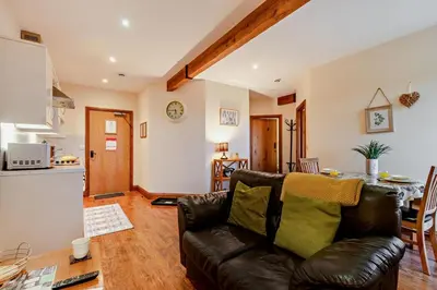 a living room with a leather couch and a kitchen at 1 Bed in Irthington oc-t28309 in Irthington