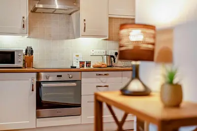 a kitchen with white appliances and a table with a lamp at 1 Bed in Irthington oc-t28309 in Irthington