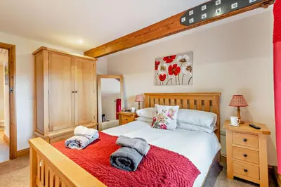 a bedroom with a large bed with a red blanket at 2 Bed in Irthington oc-m28305 in Irthington