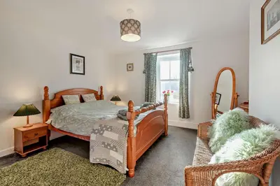 a bedroom with a bed and a chair and a window at 3 Bed in Bowness-on-Solway oc-p28797 in Bowness-on-Solway