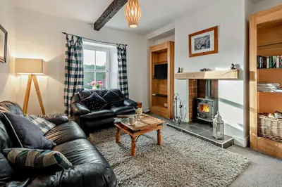 a living room with a leather couch and a fireplace at 3 Bed in Bowness-on-Solway oc-p28797 in Bowness-on-Solway