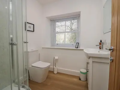 a bathroom with a toilet and a sink and a window at Dalegarth Hall Farm Cottage 1 in Holmrook