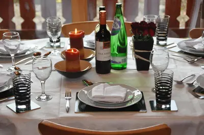 a table with a white table cloth and wine bottles at Kipplochan in Dalbeattie