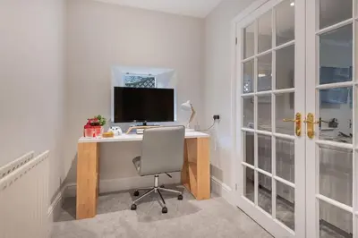 a desk with a computer and a chair in a room at Rockwood- Grasmere family cottage with Hot tub in Grasmere