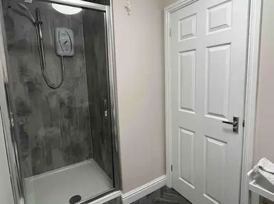 a shower stall in a bathroom with a door at The Print Room, 1 Bedroom Ground Floor Apartment in Carlisle