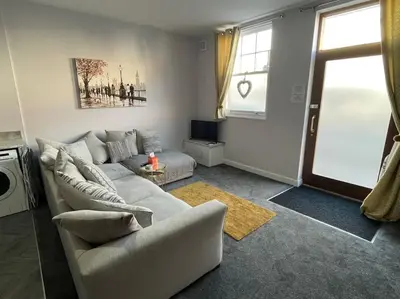 a living room with a couch and a tv at The Print Room, 1 Bedroom Ground Floor Apartment in Carlisle