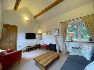 a living room with a couch and a table at Deer Close Cottage in Keswick