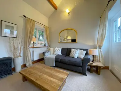a living room with a couch and a table at Deer Close Cottage in Keswick
