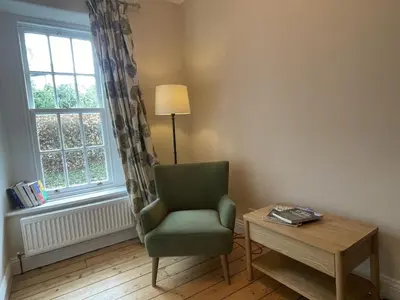 a room with a chair and a table and a window at Fell View in Portinscale