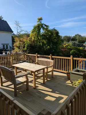 a wooden deck with a wooden table and two benches at Fell View in Portinscale