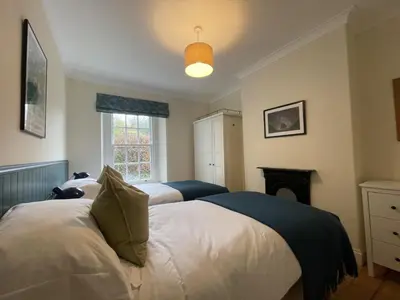 a bedroom with two beds and a fireplace at Fell View in Portinscale