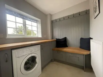 a laundry room with a washing machine and a window at Fell View in Portinscale