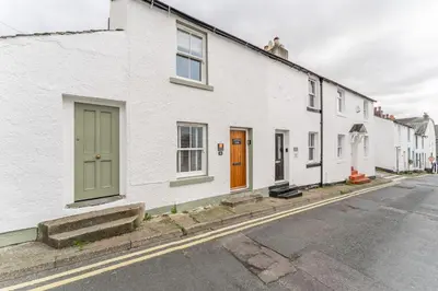 a row of white houses with green doors on a street at Little Ada in Keswick