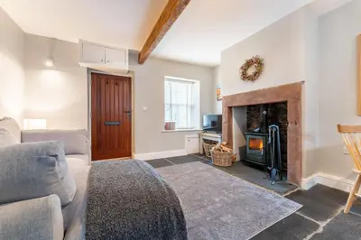 a living room with a couch and a fireplace at Little Ada in Keswick