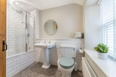 a bathroom with a toilet and a sink and a tub at Little Ada in Keswick