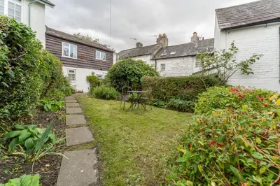 a garden with a table in the middle of two houses at Little Ada in Keswick