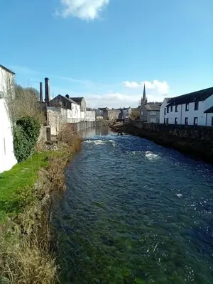a river with buildings on the side of it at Tanners Cottage in Cockermouth