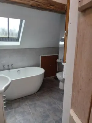 a bathroom with a white tub and a toilet at Tanners Cottage in Cockermouth