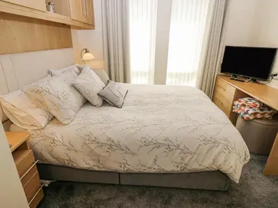 a small bedroom with a bed and a television at Plot 32 in Carlisle