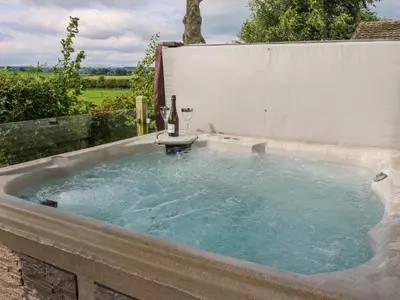 a hot tub with a bottle of wine in it at Plot 32 in Carlisle