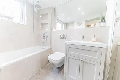 a white bathroom with a toilet and a sink at Otterbield, Derwent House, Portinscale in Portinscale