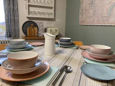 a wooden table with bowls and plates on it at Laurel Bank House in Penrith