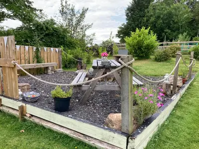 a garden with a wooden fence and some flowers at Laurel Bank House in Penrith