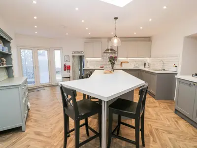 a kitchen with a white table and chairs at Smithy House in Dumfries