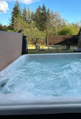 a large jacuzzi tub in a backyard at Odea Hot tub Holiday Cottage in Dumfries