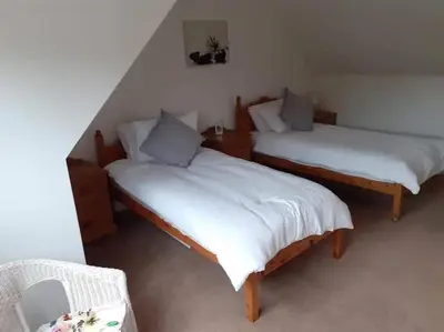 two beds with white sheets in a room at Odea Hot tub Holiday Cottage in Dumfries
