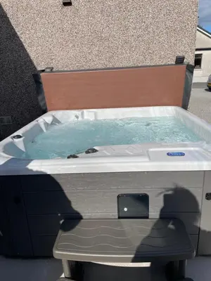 a jacuzzi tub sitting in front of a building at Odea Hot tub Holiday Cottage in Dumfries