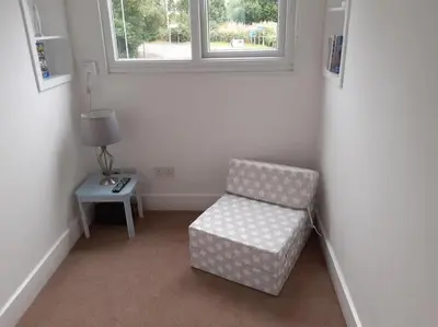 a room with a chair and a table and a window at Odea Hot tub Holiday Cottage in Maxwelltown