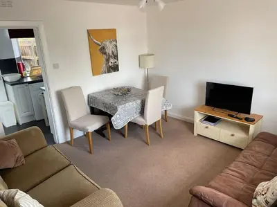 a living room with a table and a couch at Odea Hot tub Holiday Cottage in Maxwelltown