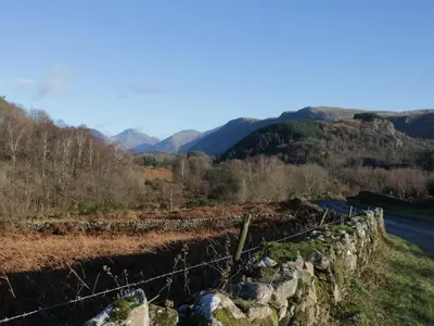 a fence on the side of a hill with a road at The Barn in Seascale