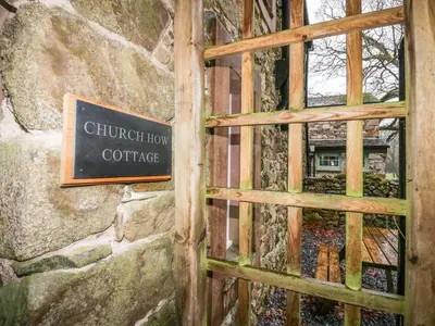 a door to a building with a sign on it at Church How Cottage in Seascale