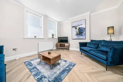 a living room with a blue couch and a coffee table at Central Gretna Luxury 4 bed in Gretna
