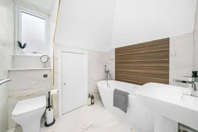 a bathroom with a tub and a sink and a toilet at Central Gretna Luxury 4 bed in Gretna