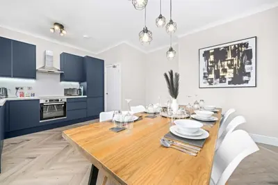 a dining room and kitchen with a wooden table and chairs at Central Gretna Luxury 4 bed in Gretna
