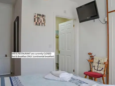 a bedroom with a bed and a flat screen tv at Hope & Anchor, Hadrian's Wall, Port Carlisle, Solway Firth, Area of Natural Beauty in Port Carlisle