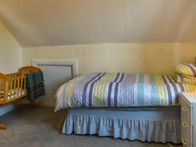 a small bedroom with a bed and a crib at Teazles in Peel