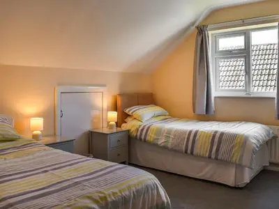 a bedroom with two beds and a window at Teazles in Peel