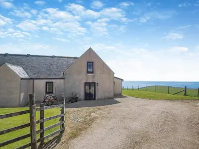 a house with a fence next to the ocean at Barnstable - Uk46888 in Kilmory