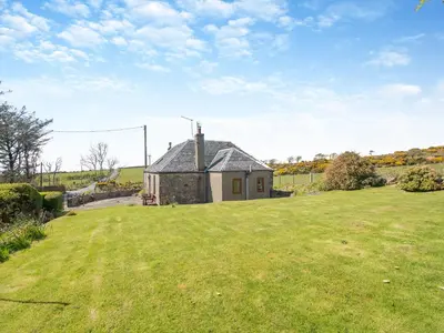 a house in the middle of a grassy field at Kilbride Cottage-Uk46886 in Kilmory
