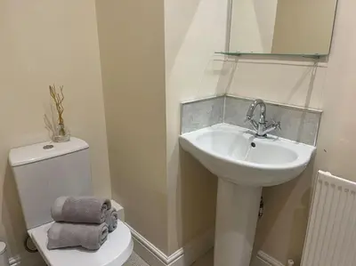 a bathroom with a sink and a toilet and a mirror at Thurnams House, Ground Floor Apt in Carlisle