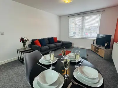 a living room with a dining table and a couch at Curwen Apartment - 2 Bedrooms - Sleeps 6 in Workington
