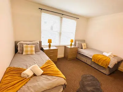 a bedroom with two beds and a window at Curwen Apartment - 2 Bedrooms - Sleeps 6 in Workington