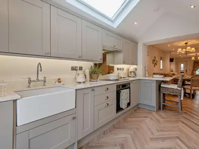 a kitchen with white cabinets and a large sink at 2 Bed in Cockermouth 94787 in Broughton Moor