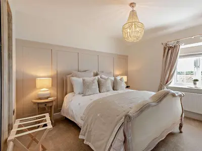 a bedroom with a large bed and a chandelier at 2 Bed in Cockermouth 94787 in Broughton Moor